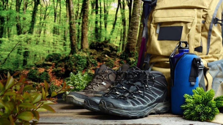 A backpack, two set of hiking boots, and a water bottle.