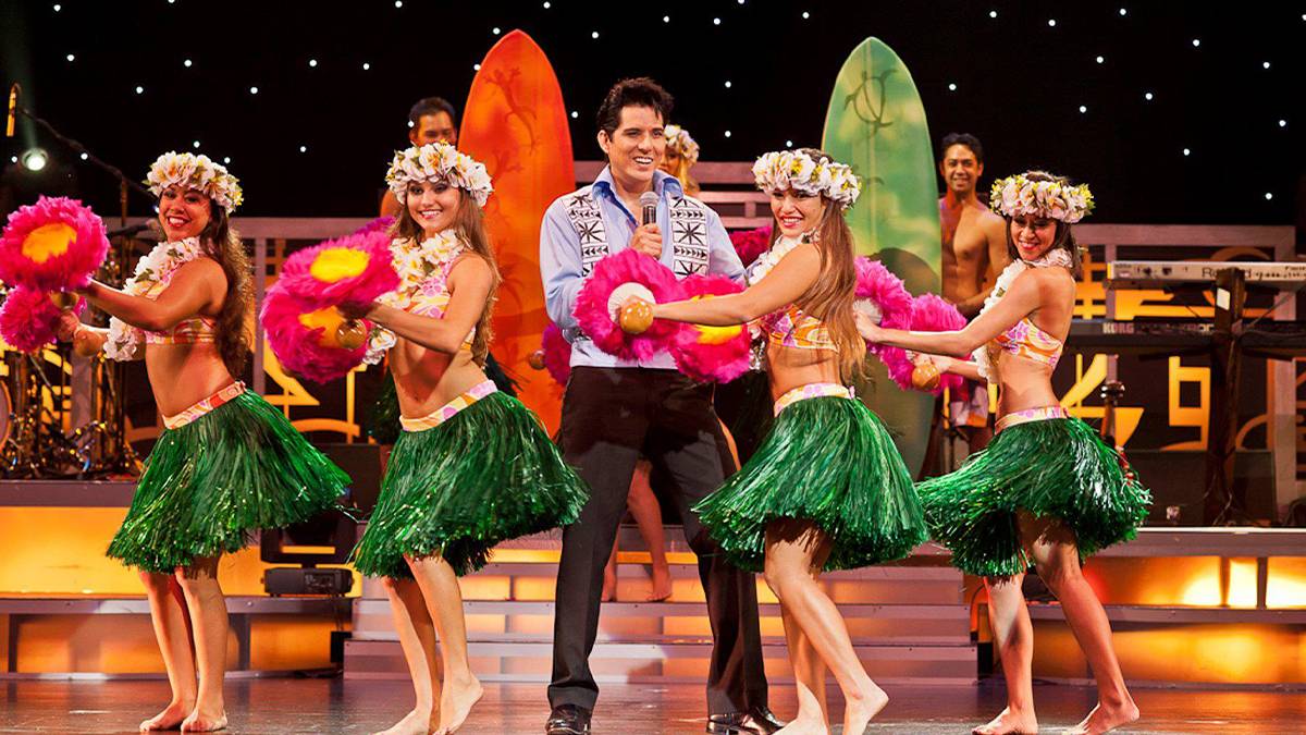 Hula dancers and an Elvis impersonator on stage at Rock-a-Hula in Honolulu, Hawaii, USA