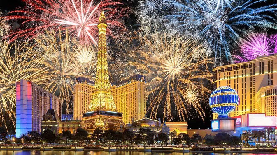 Wide shot of fireworks behind the Eiffel Tower and other buildings for NYE in Las Vegas, Nevada, USA
