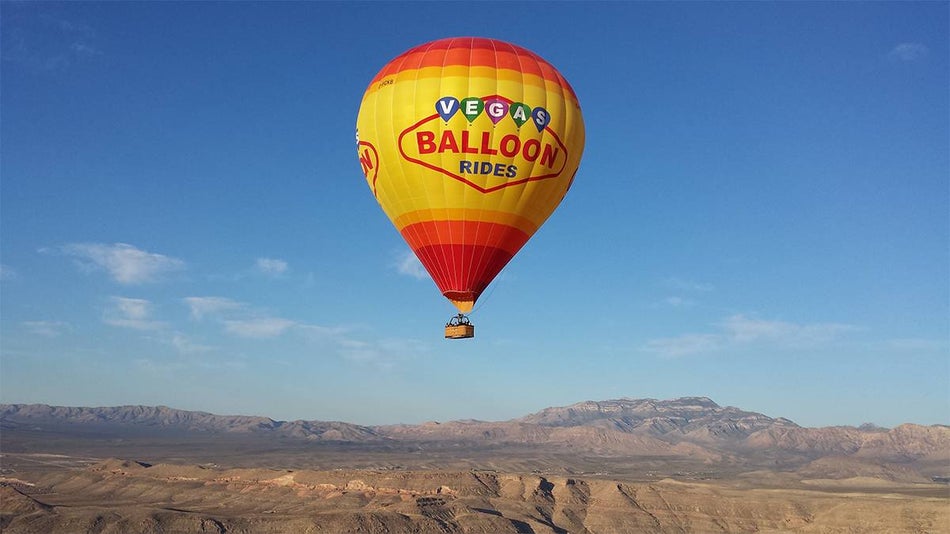 A large red and yellow hot air balloon in the sky as part of Vegas Balloon Rides in Las Vegas, Nevada, USA
