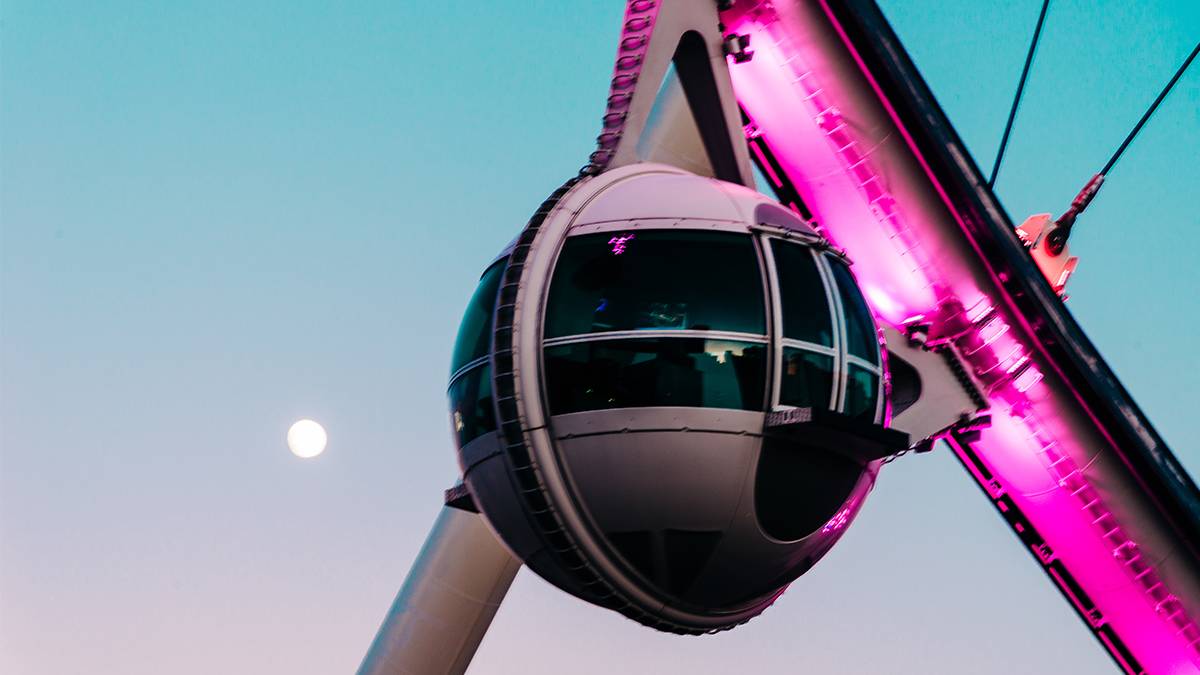 Close up photo of a pod on the High Roller Observation Wheel in the evening with the moon in the background in Las Vegas, Nevada