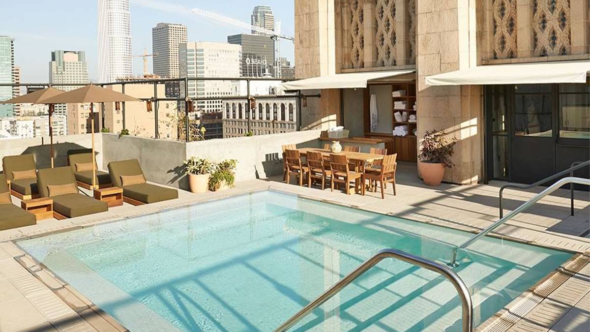 View of the upstairs pool and lounge area at Ace Hotel on a sunny day with the cityscape in the back ground in Los Angeles, California, USA