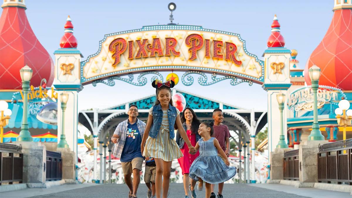 family with two little girls walking in front of Pixar Pier at Disney California Adventure in Los Angeles, California, USA