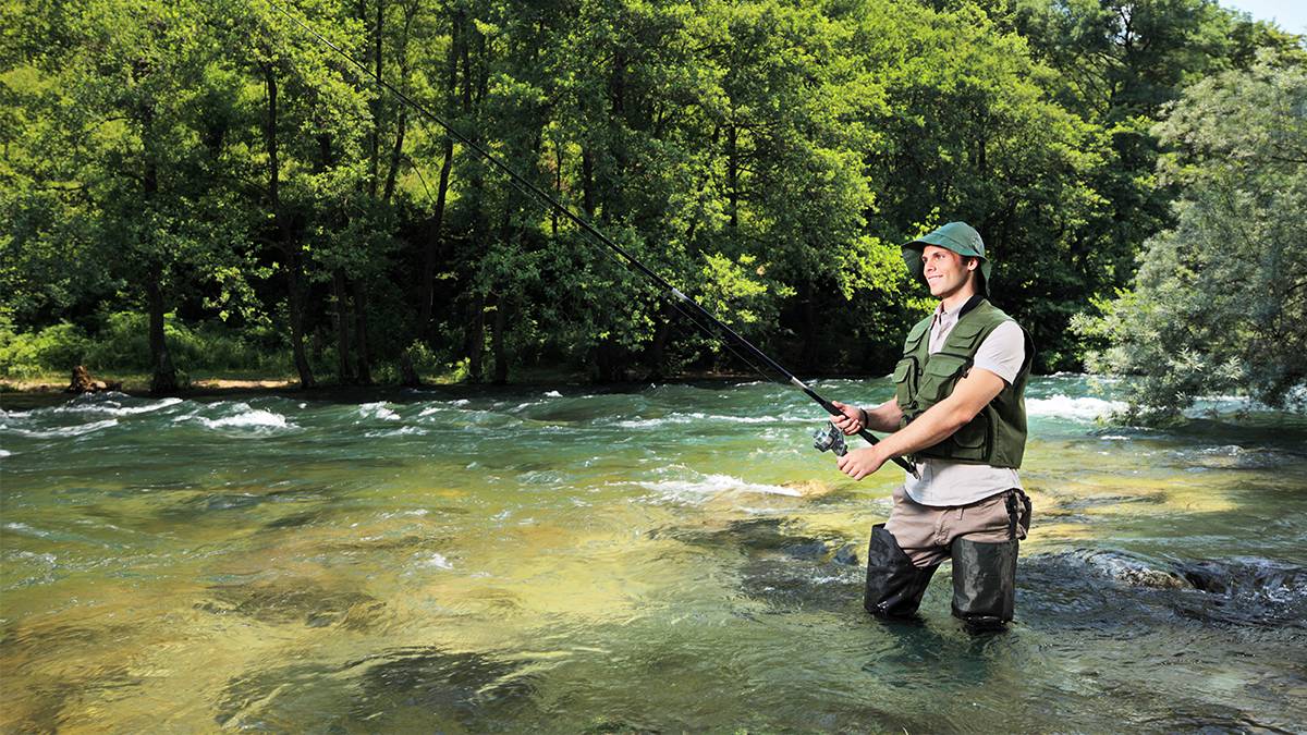 man trout fishing in stream