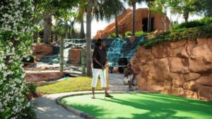 Mom and son on mini golf course during sun light at Shipwreck Island Adventure Golf in Myrtle Beach, South Carolina, USA