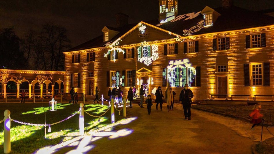 mt vernon estate at night with christmas lights and snowflake light projections