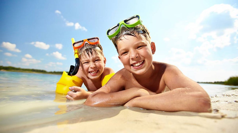Kids wearing googles enjoying a swim on a beach