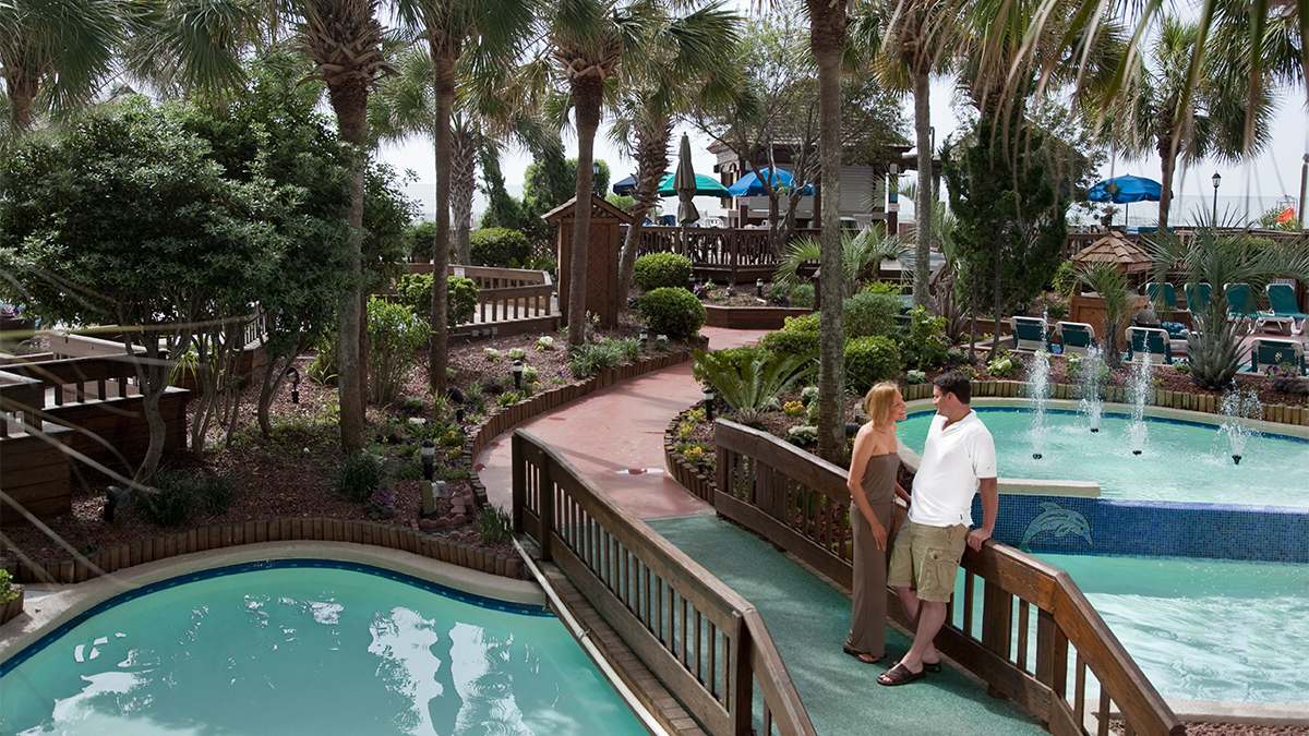 Couple standing on a bridge over the pools at Beach Cove Resort - Myrtle Beach, South Carolina, USA