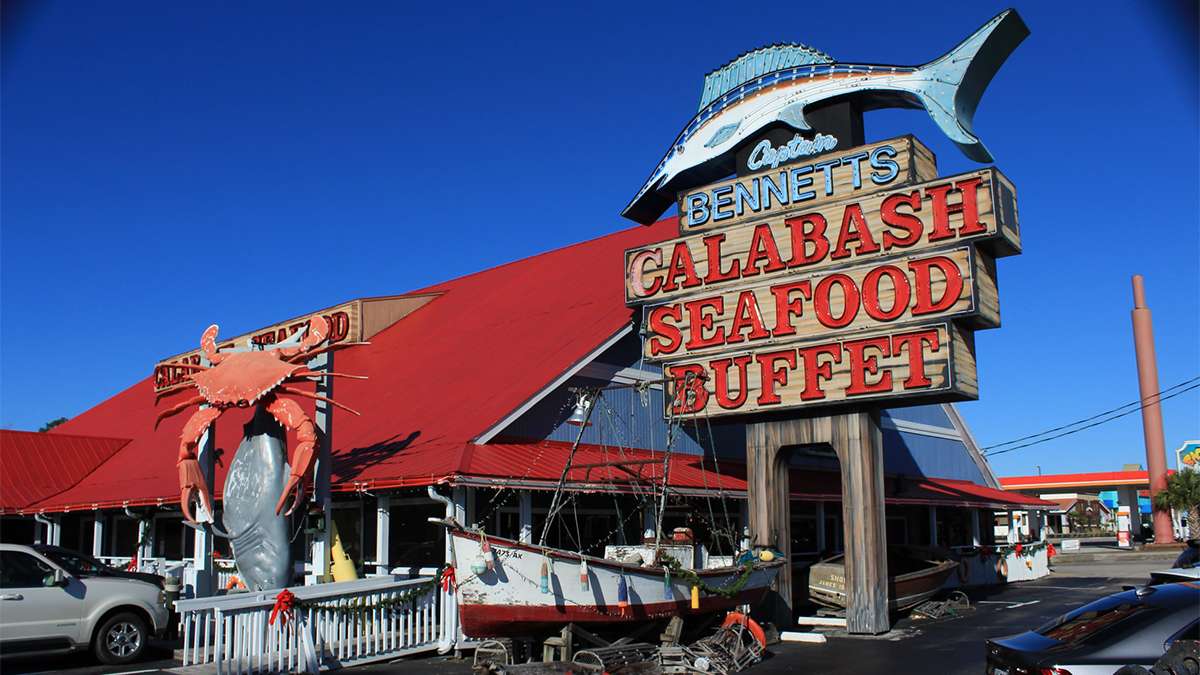 exterior day view of Bennett's Calabash Seafood restaurant sign during daytime with palm trees in Myrtle Beach, South Carolina, USA