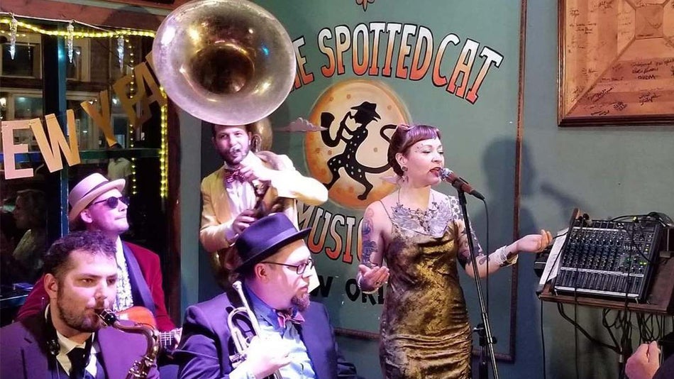 View of a band at The Spotted Cat building at night with crowds of people outside in New Orleans, Louisanna, USA