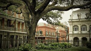 Exterior view of the French Quarter with gardens and large tree in New Orleans, Louisiana, USA