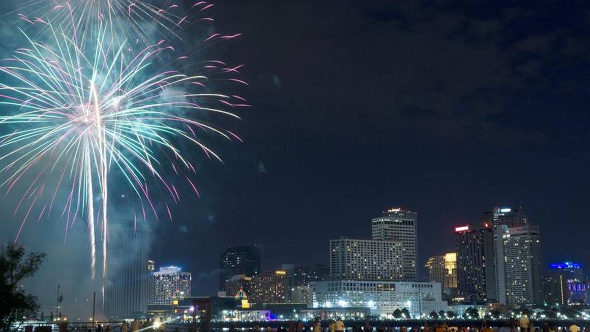 Wide shot of a large firework in the sky with the city of New Orleans behind it for New Years Eve in New Orleans, Louisiana, USA