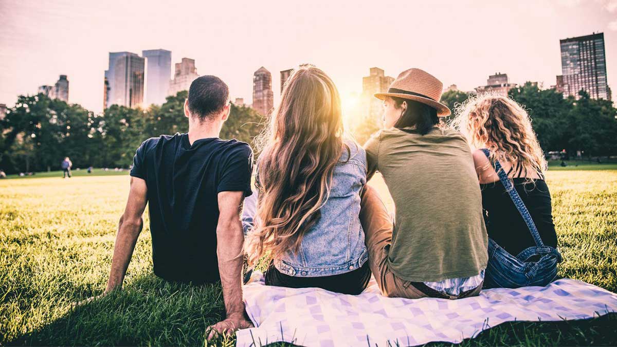 Friends enjoying the summer in Central Park overlooking the NYC skyline - 12 of the Best Things to Do in NYC in the Summer
