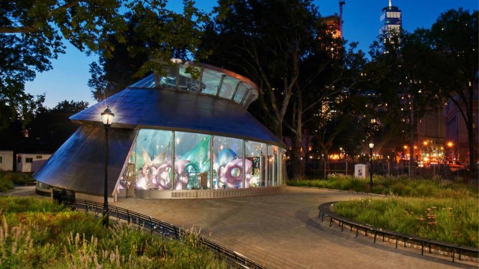 Twilight evening view of SeaGlass Carousel at Battery Park with NYC, New York, USA skyline in the background