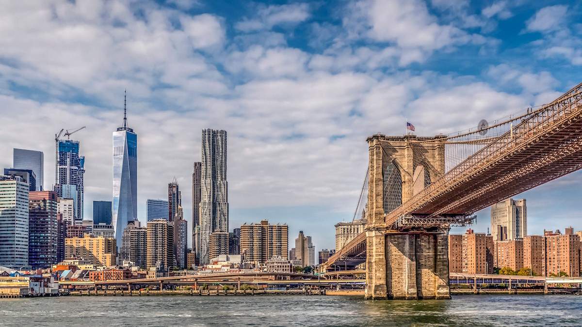 view across East River and Brooklyn Bridge with the Manhattan skyline in background in NYC, New York, USA