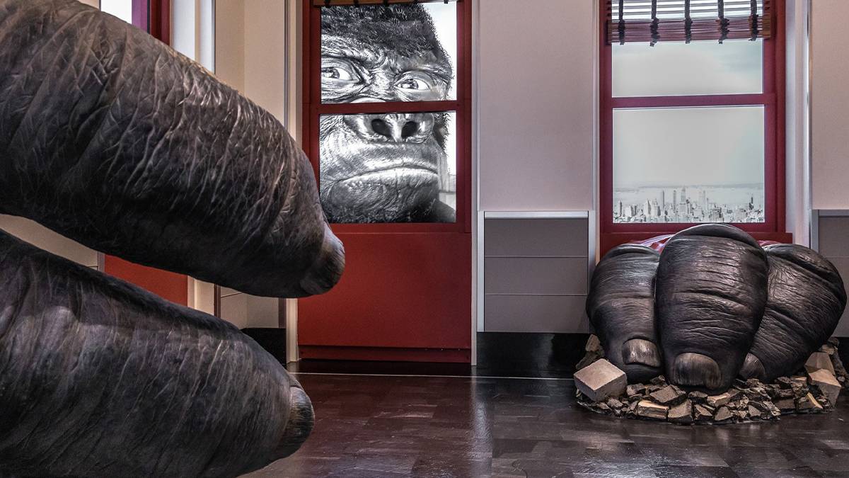 Close up of King Kong's hands breaking through the walls of the Empire State Building and his face on the other side of the window in NYC, New York, USA