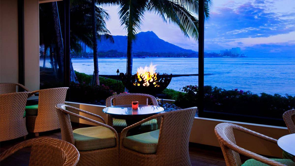 View of firepit at twilight with Diamond Head in background at RumFire restaurant in Oahu, Hawaii, USA