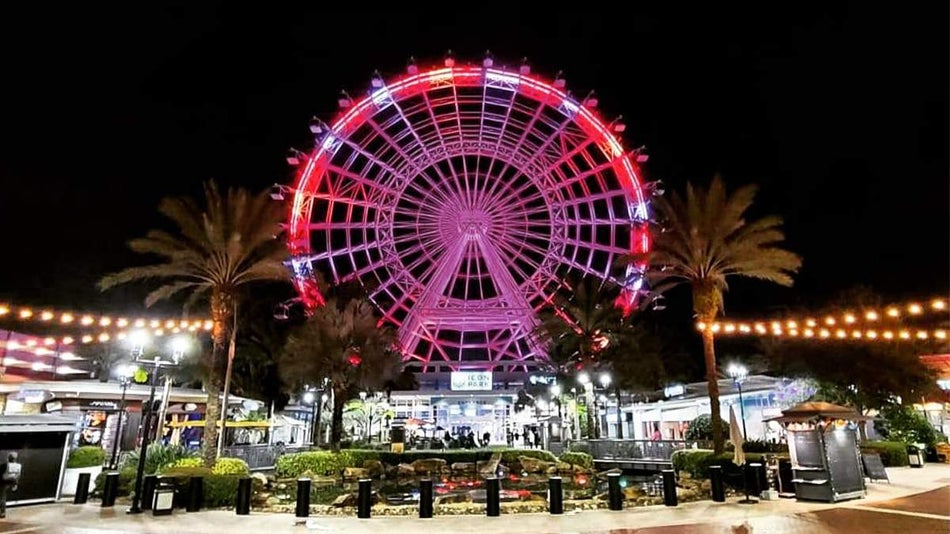 The Wheel at ICON Park lit up red and white at night in Orlando, Florida, USA