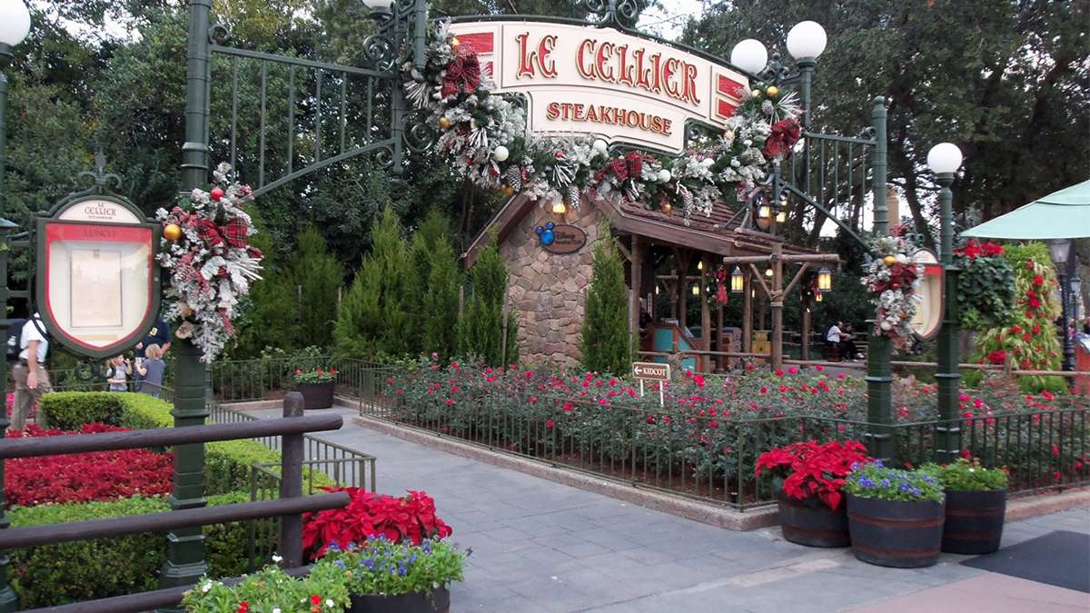 View of the entrance to to Le Cellier Steakhouse with flowers on either side of the arched iron entrance in Orlando, Florida, USA
