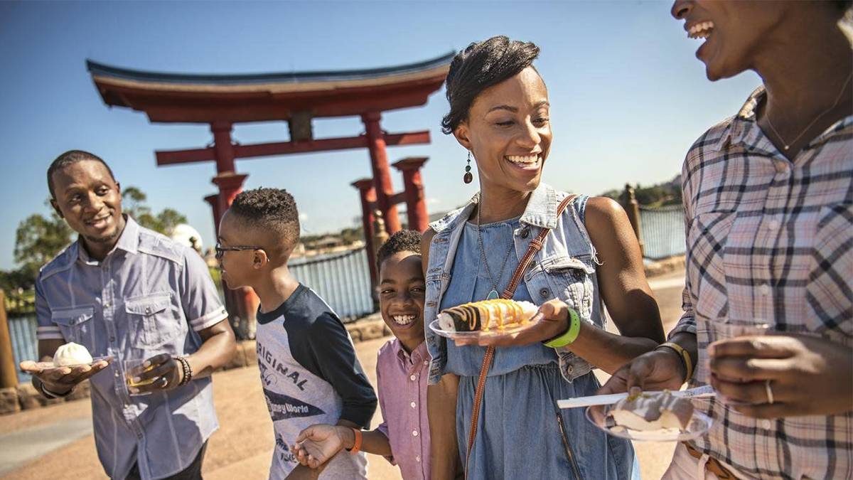 Family walking with desserts in their hands at the Epcot International Food & Wine Festival at Walt Disney World in Orlando, Florida, USA