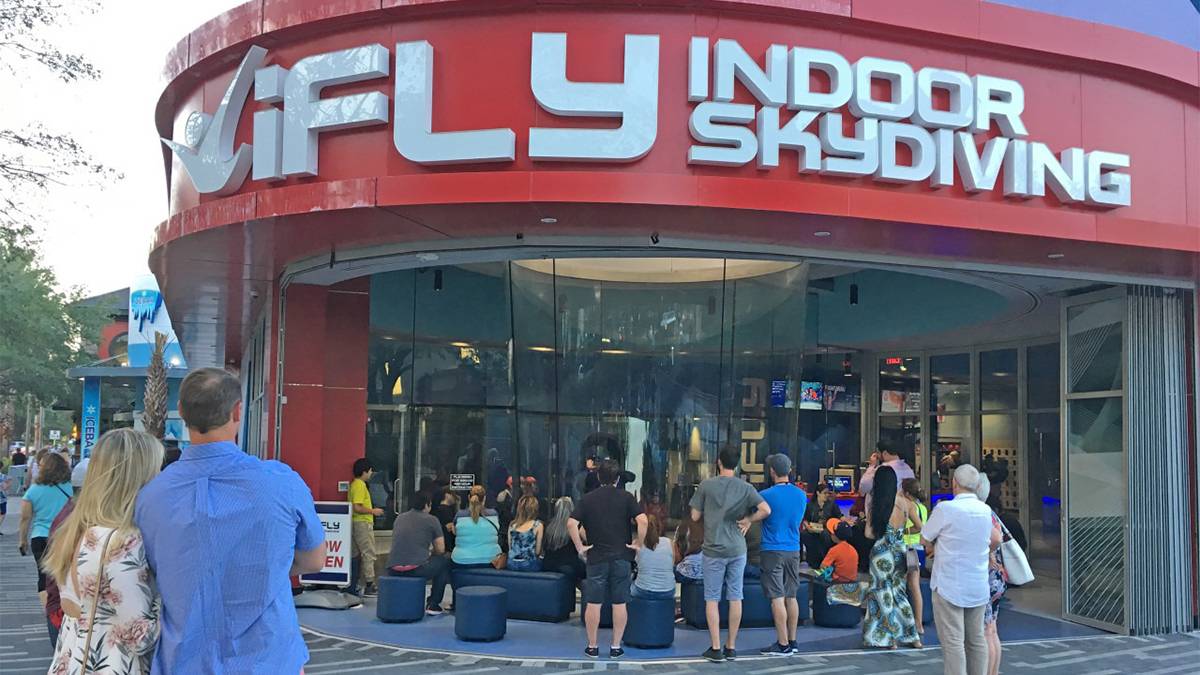 A group of people standing outside of iFly Orlando watching someone indoor sky dive in Orlando, Florida, USA
