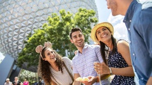 family laughing and enjoying food at Epcot International Food & Wine Festival at Walt Disney World in Orlando, Florida, USA