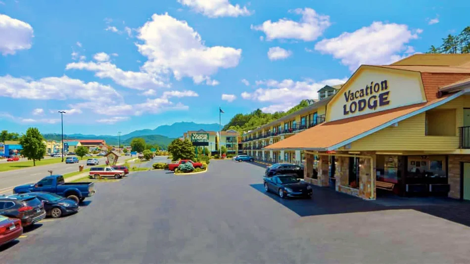 Exterior view of the front of Vacation Lodge with parked vehicles - Pigeon Forge, Tennessee, USA