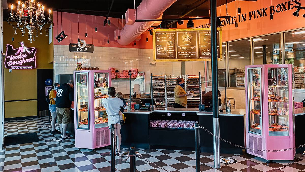 Wide shot of the black, white, and pink interior of VooDoo Doughnut in Portland, Oregon, USA