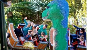 Close up photo of people on Coastersaurus and a Giant Lego Dinosaur at LEGOLAND California on a sunny day in San Diego, California, USA