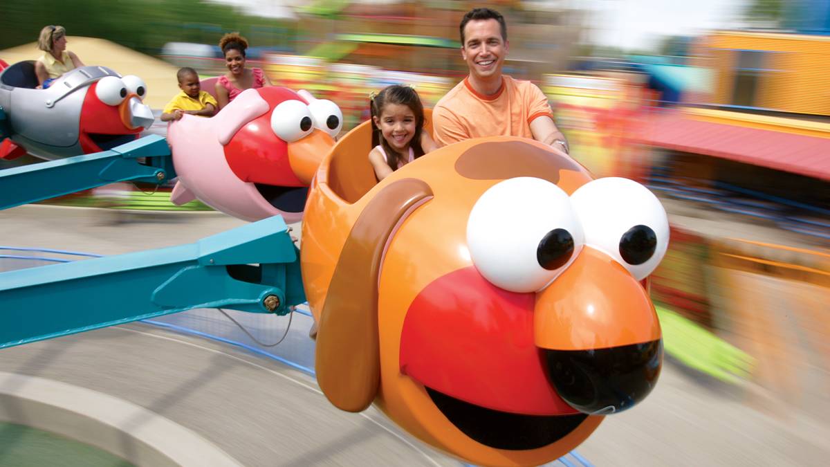 Close up of children and their parents riding Elmo's Flying Fish at SeaWorld in San Diego, California, USA