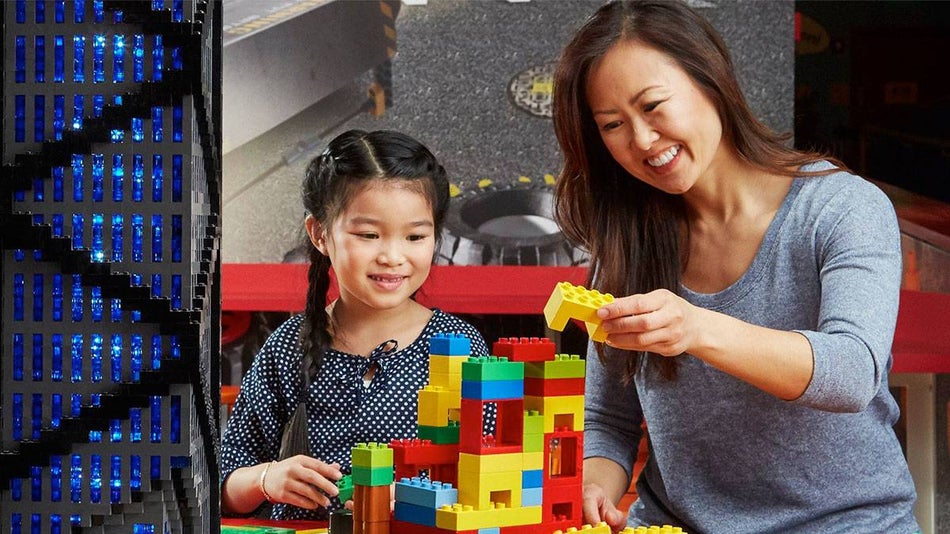 Close up of mother and daughter playing with legos at LEGOLAND in San Diego, California, USA