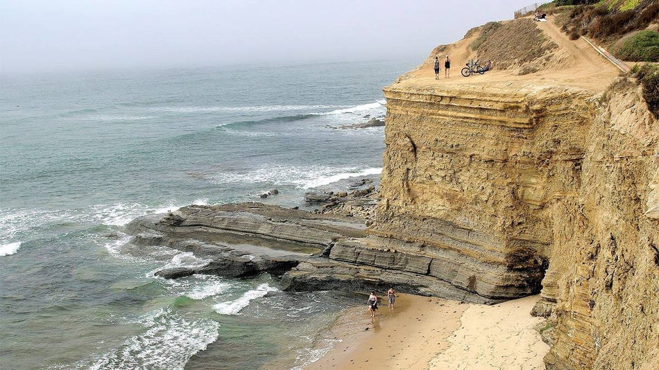 Wide shot of where the ocean meets Sunset Cliffs Natural Park and part of the beach in San Diego, California, USA