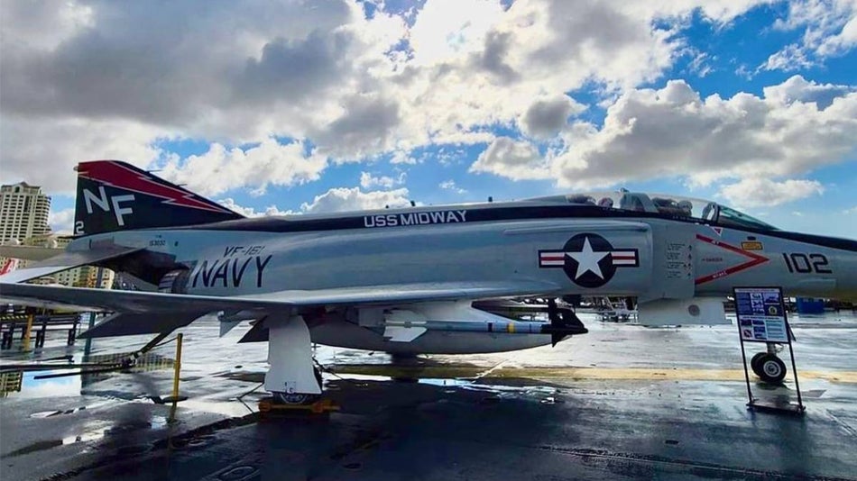 Close up photo of a Navy airplane on the USS Midway with a blue and cloudy sky in the background in San Diego, California