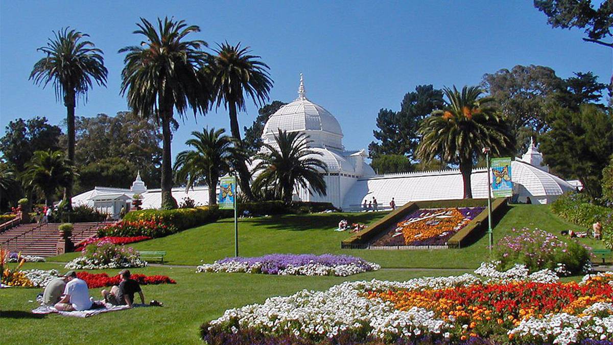 Flowers and People sitting on a blanket at the Conservatory of Flowers at Golden Gate Park in San Francisco, California, USA