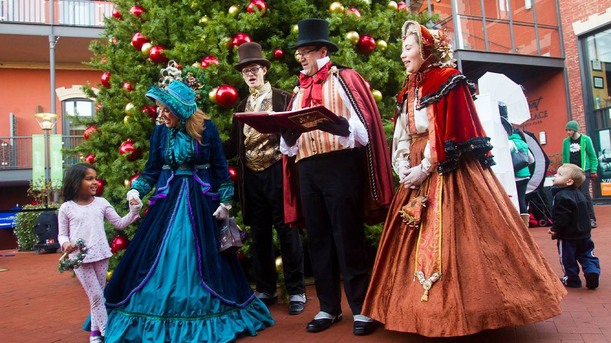 Close up photo of carolers singing in front of a Christmas tree at Ghirardelli Square Holiday Marketplace & Christmas Tree Stroll in San Francisco, California, USA.