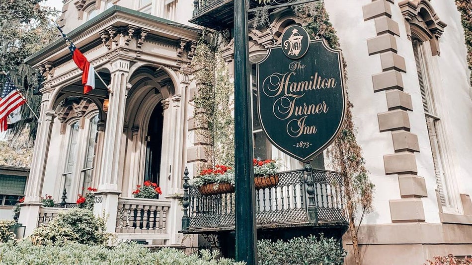 Close up photo of the sign for Hamilton-Turner Inn with the entrance to the Inn in the back ground in Savannah, Georgia, USA