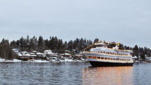 Wide shot of an Argosy Cruise Boat on the water with lights on on a snowy winter day in Seattle, Washington, USA