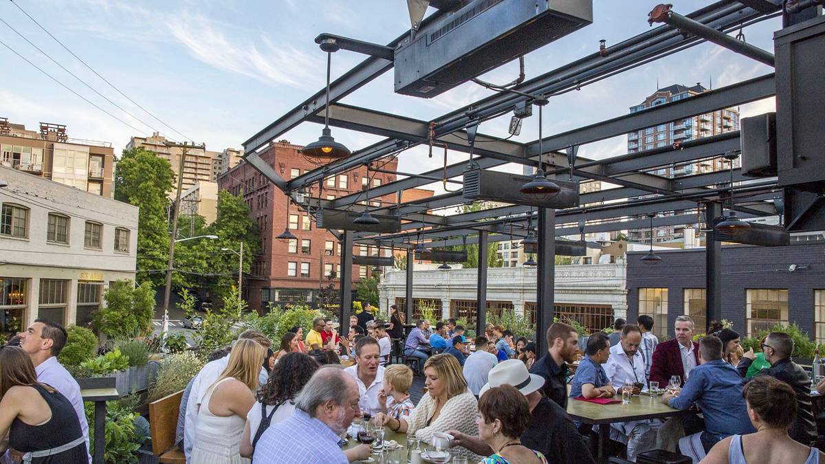 The outdoor rooftop dining area filled with people eating at Terra Plata in Seattle, Washington, USA