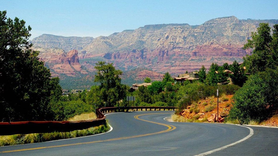 Close up of winding road with red rocks in the background in Sedona, Arizona, US