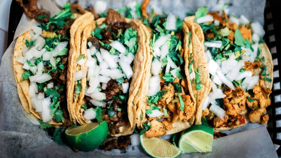 Close up photo of street tacos with lots of white onion