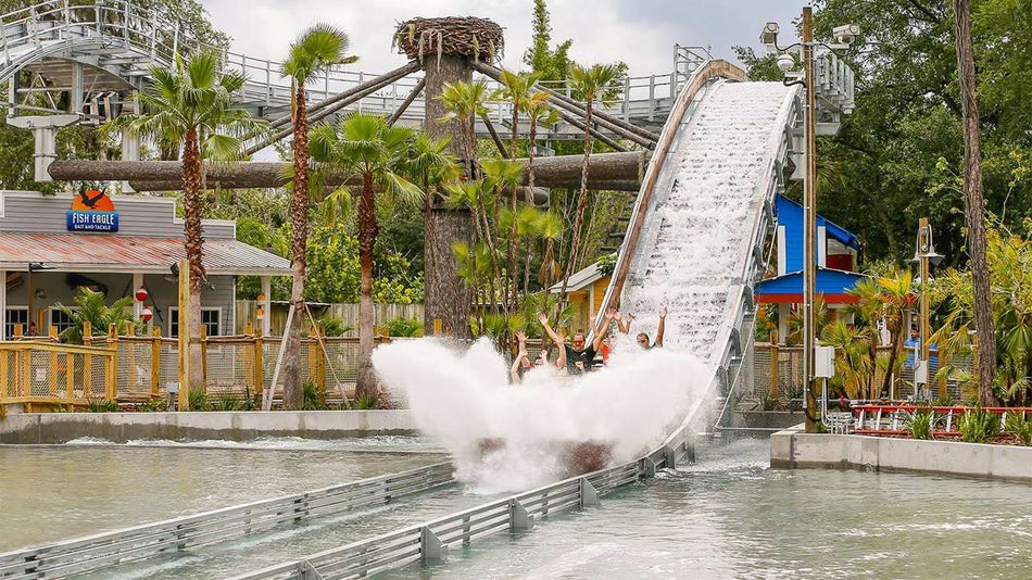 View of people splashing in the water at the bottom of Roaring Springs coaster at ZooTampa in Tampa, Florida, USA