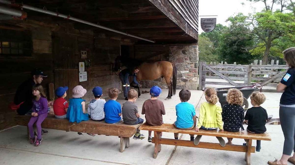 Children looking at a woman with a brown horse at Riverdale Farm near Toronto, Ontario, Canada
