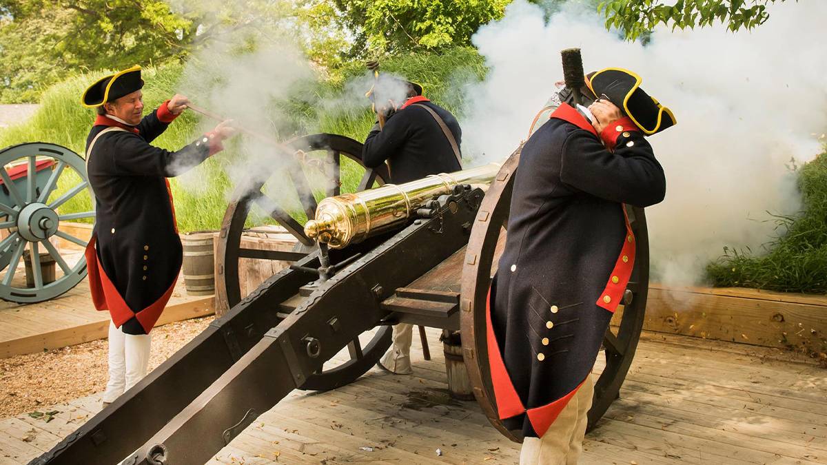 colonial dressed soldiers shooting canon at fourth of july celebration at the Jamestown Settlement American Revolution Museum of Yorktown in Williamsburg, Virginia, USA