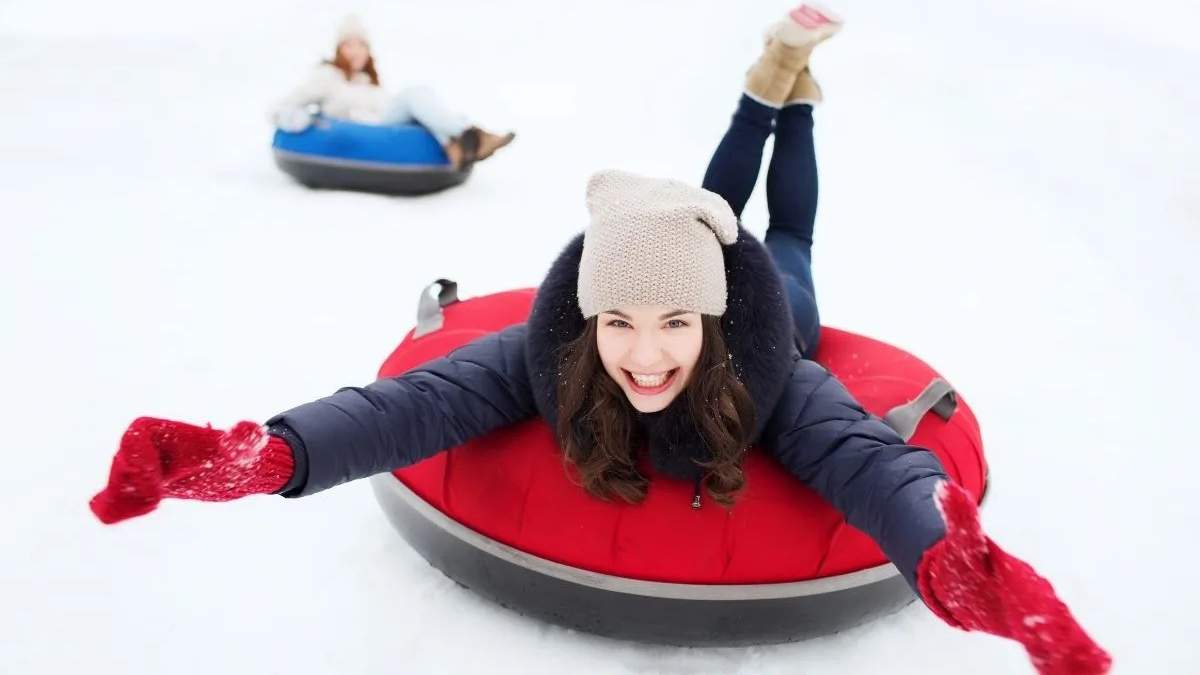 Two friends snow tubing