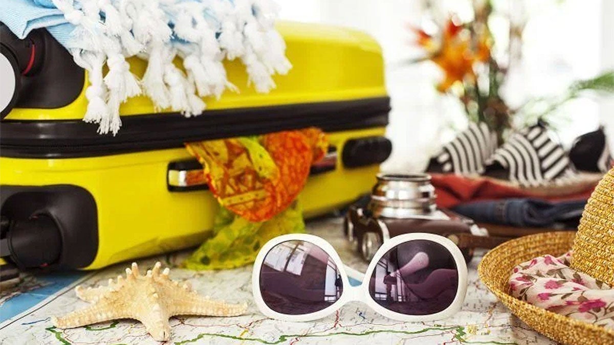 close up of travel concept of yellow suitcase and sunglasses with hat