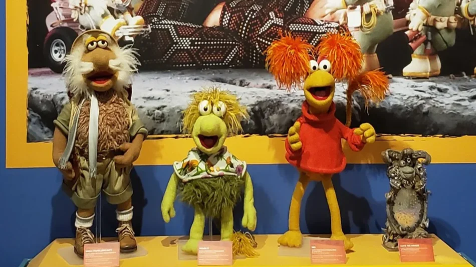 Close up of the some of the puppets used in the show Fraggle Rock with a blue wall behind them at the Center for Puppetry Arts in Atlanta, Georgia