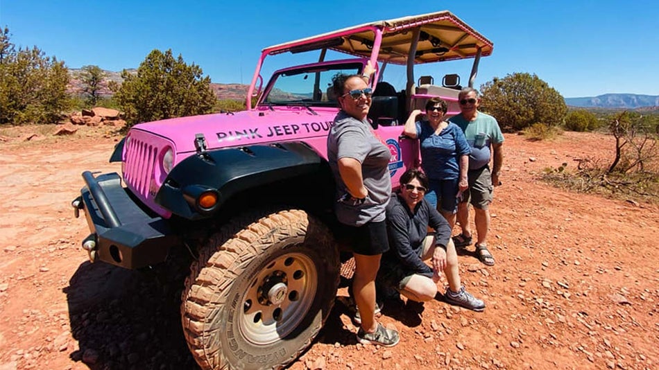 group of friends standing next to pink jeep in desert on sunny day at Diamondback Gulch Jeep Tour in Sedona, Arizona, USA