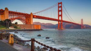 ground view of Golden Gate Bridge with bay at sunset in San Francisco, California, USA