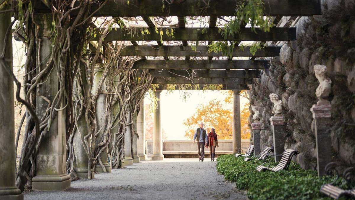 couple holding hands walking together under the pergola at the Biltmore Estate in Asheville, North Carolina, USA