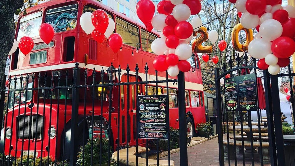 Wide shot of Double D’s Double Decker Bus and its outdoor dining area decorated with red and white balloons in Asheville, North Carolina, USA